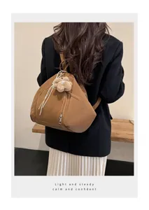Back view of a minimalist brown triangle backpack worn with a black blazer.