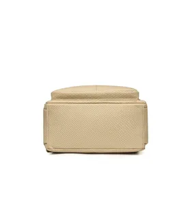 Detail view of the bottom of a minimalist beige travel backpack showing fabric texture