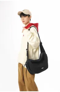 Black large-capacity crossbody dumpling bag worn by model for commuter style
