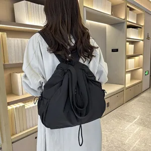 Detail view of a black nylon casual backpack, lightweight and spacious for daily use.