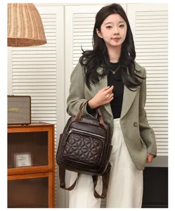 Vue détaillée d'un sac à dos matelassé en cuir PU marron foncé avec fermetures pratiques.