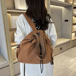 Detail view of the casual brown nylon backpack showing drawstring design and durable fabric.