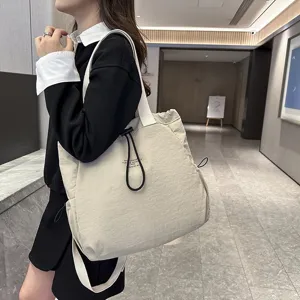Detailed view of the casual nylon backpack, stylish beige shoulder bag for daily commute.