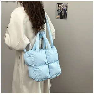 Detailed view of a light blue quilted padded tote bag showing large capacity and soft texture