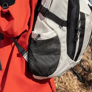 Close-up of white outdoor hiking backpack detail featuring black mesh side pockets