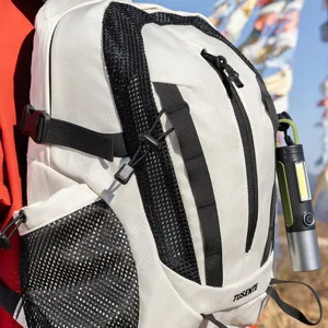 Close-up of a lightweight white hiking backpack with an attached outdoor COB flashlight