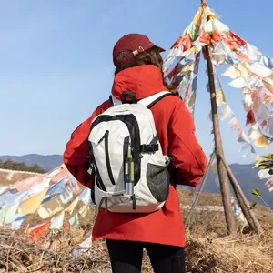 Back view of a white outdoor hiking backpack worn by a traveler in a scenic mountain setting