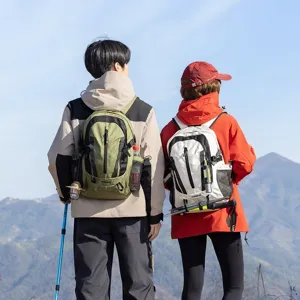 Couple wearing green and white lightweight outdoor hiking backpacks in scenic mountain