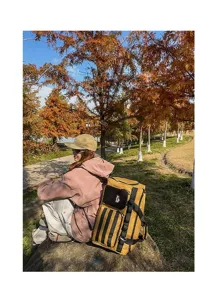 Grand sac à dos de voyage d'extérieur en jaune moutarde avec rayures verticales noires.