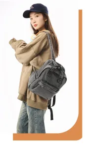 Washed denim gray small backpack worn by model in a casual lifestyle setting