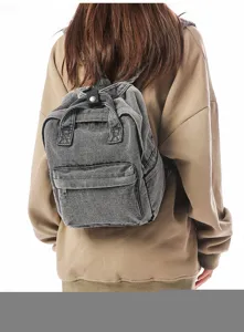 Close-up detail of a vintage gray washed denim small backpack for casual travel use