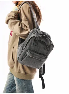 Close-up of a vintage washed denim small backpack worn by a model in lifestyle view