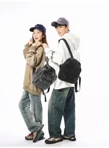 Lifestyle view of vintage washed denim small backpacks worn by models in a casual setting
