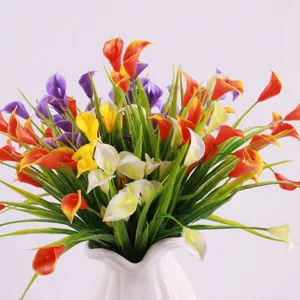Detailed macro view of multi-colored artificial calla lily and green spring grass bouquet.