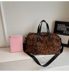 Borsone da viaggio leopardato con manici neri e piccola pochette coordinata, dettaglio.