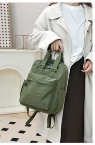 Close-up detail of casual green nylon backpack with front pocket and top handle style.