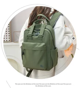 Detailed view of the green nylon casual backpack showing front pocket and zipper design.