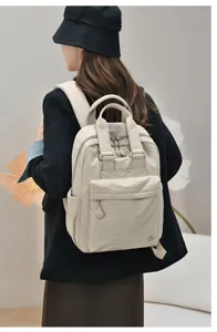 Backpack detail view showing the back-wearing style, minimalist nylon design for daily use.