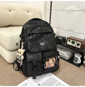 Casual camouflage student backpack with large capacity, multi-pocket design, and cute bear charm.