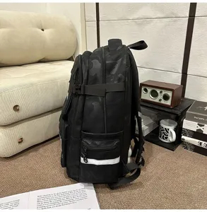 Detail view of black camouflage backpack with multiple compartments, side pockets and straps.