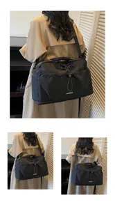 Détail de sac de voyage noir montrant un tissu léger, une bandoulière et un cordon de serrage.