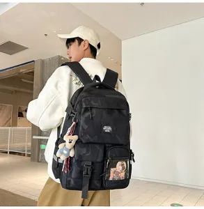Detailed view of the stylish camo backpack with multiple pockets and a cute bear keychain.