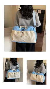 Vue détaillée du grand sac de voyage avec bandoulière et design élégant bicolore.