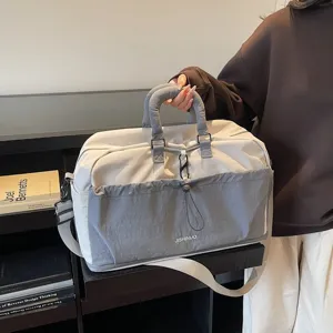 Vue détaillée du grand sac de voyage avec poche avant et poignées solides pour le sport.