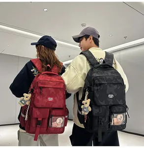 Stylish camouflage backpack with cute bear pendant, large capacity school bag for daily commuting.