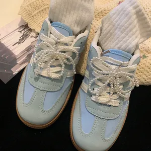 Détail de breloques de chaussures nœud en perles sur lacets de baskets bleu clair