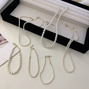 Detailed macro view showing several white pearl necklaces and bracelets with gold-tone clasps.