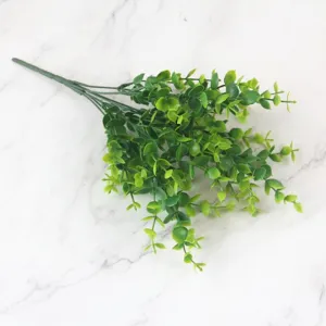 Realistic artificial eucalyptus bundle with seven branches placed on a white marble surface.