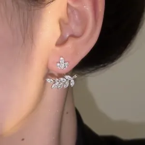 Primer plano de pendientes de espiga de trigo brillantes en plata con circonitas