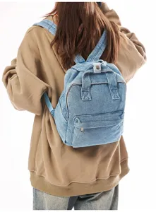 Back view of a woman wearing a light blue washed denim backpack in a casual style