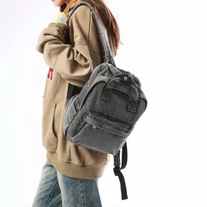 Grey vintage washed denim mini backpack for women shown on model in a stylish side view
