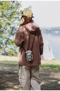 Model met een grijze tactische mini-crossbodytas in een buitenomgeving bij kamperen