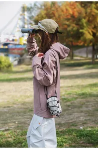 Gedetailleerde opname van een kleine tactische crossbody telefoontas in een buitenomgeving
