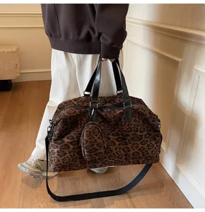 Dettaglio della borsa da viaggio leopardata, con tessuto strutturato e cinghie nere.