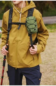 Gedetailleerde weergave van de groene tactische tas aan de riem van de rugzak buiten.