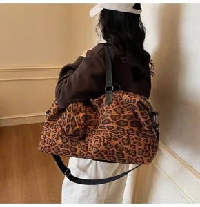 Vista dettagliata di una borsa da viaggio da donna con stampa leopardata e tracolla.