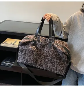 Dettaglio della borsa da viaggio leopardata con tessuto morbido e manici neri resistenti.