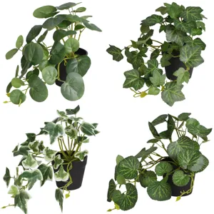 Detailed view of four different artificial green plants in black pots for indoor decor