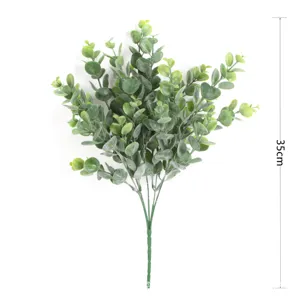 Close-up detail of artificial eucalyptus branch with frosted green leaves for decor.