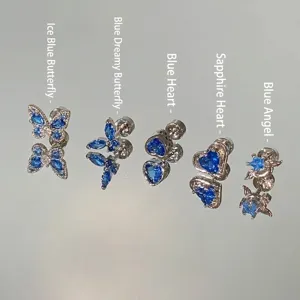 Detailed view of five sparkling blue crystal stud earrings in butterfly and heart shapes