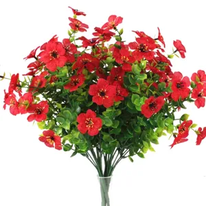 Detail of vibrant red artificial flowers with green eucalyptus leaves on white background