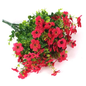 Macro detail of artificial red flower bouquet with green eucalyptus leaves