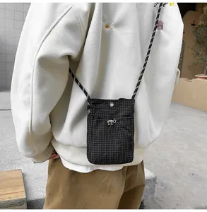 Vista posteriore di un modello che indossa una borsa a tracolla nera a scacchi