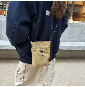 Vista dettagliata di una borsa a tracolla a quadretti indossata in un contesto urbano