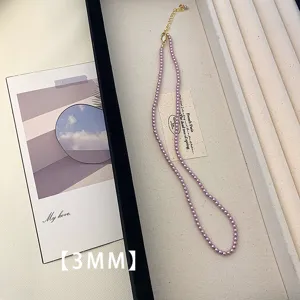 Close-up detail of 3mm purple pearl necklace arranged in elegant white display tray