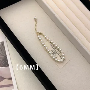 Close-up of elegant 6mm white pearl necklace in a cream jewelry display tray.
